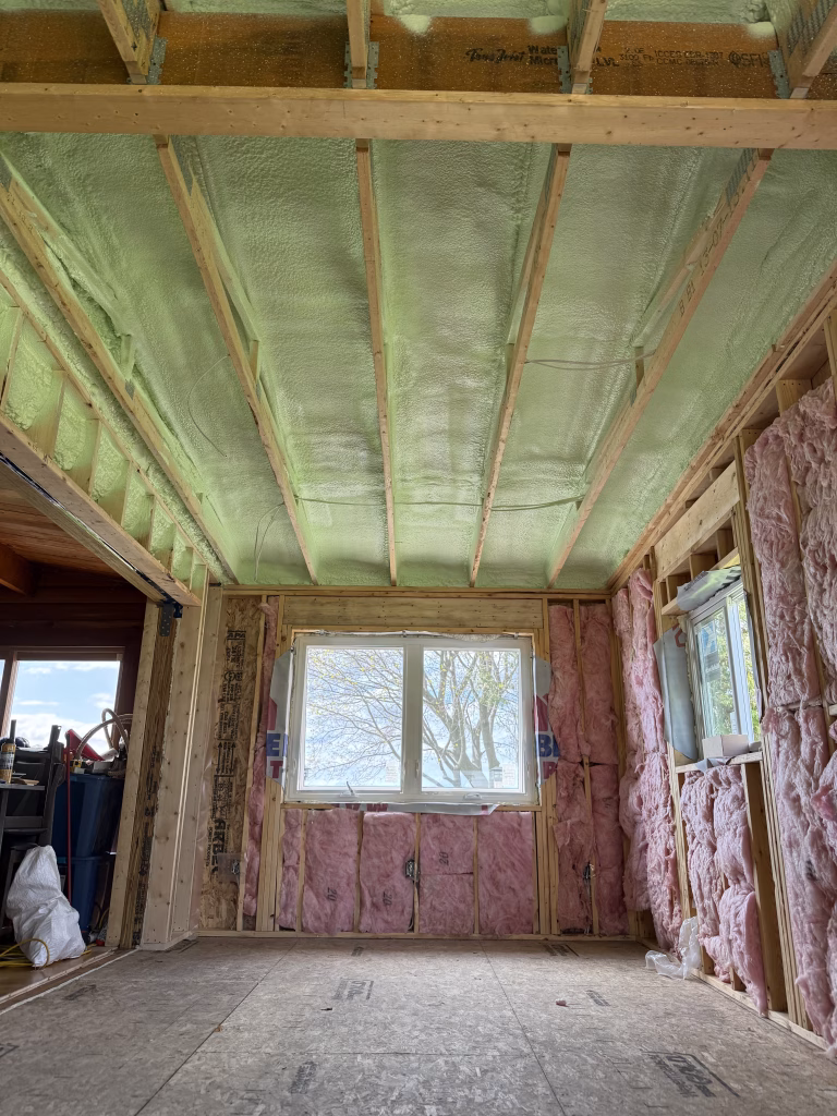 Spray foam insulation applied between ceiling joists in a residential home in Peterborough, Ontario.
