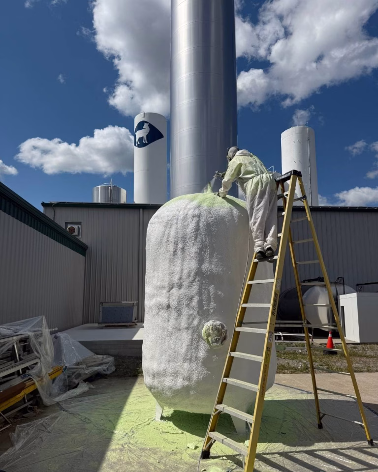 Spray foam technician finishing spray foam insulation application.