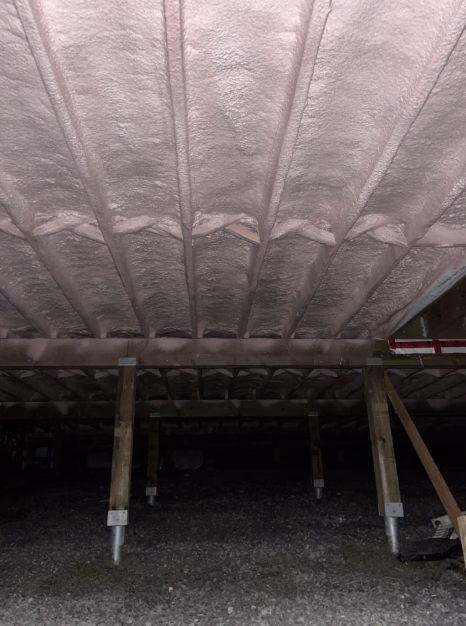 Spray foam insulation applied to flooring in a crawlspace.